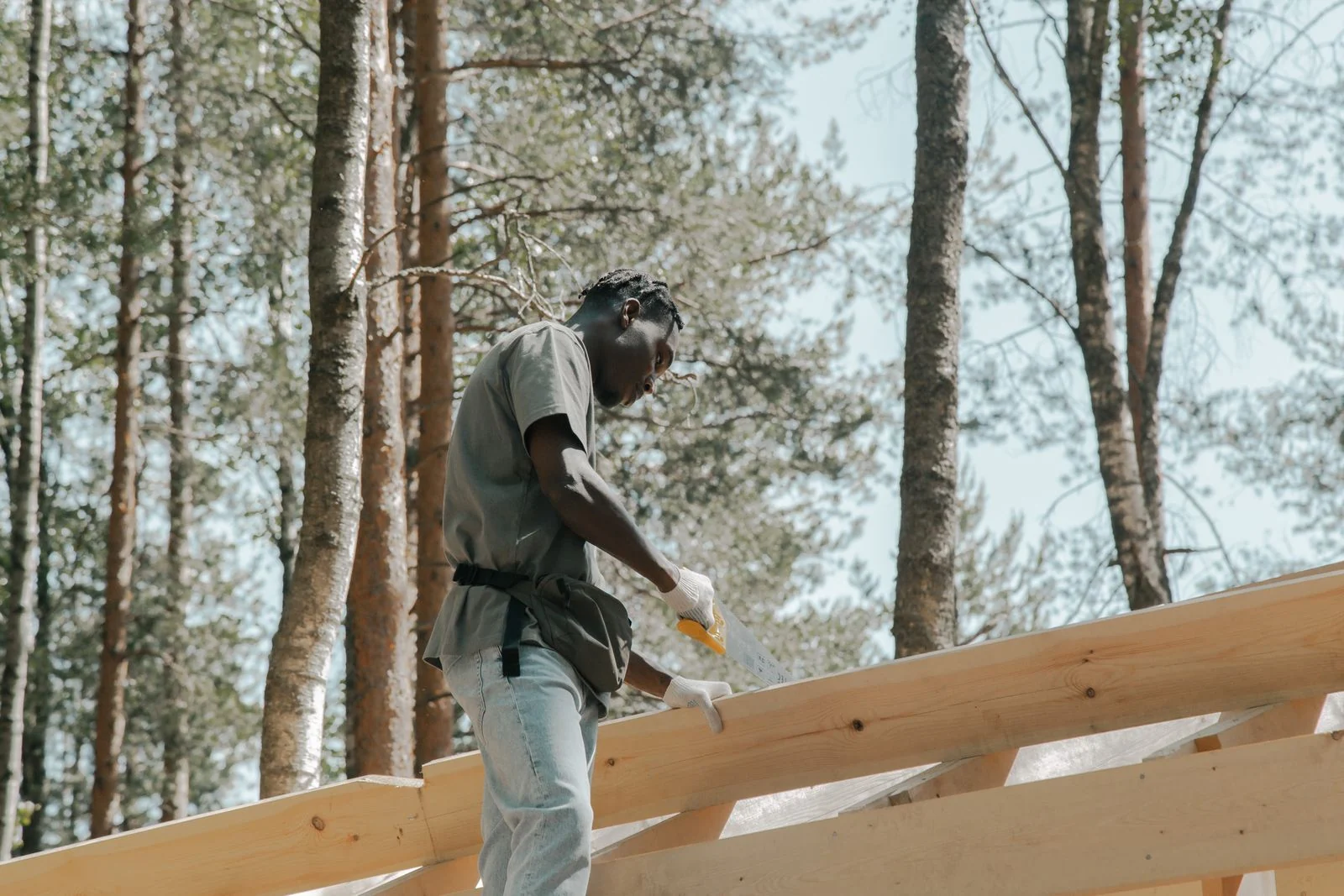 Carpenter sawing timber framing on a construction project